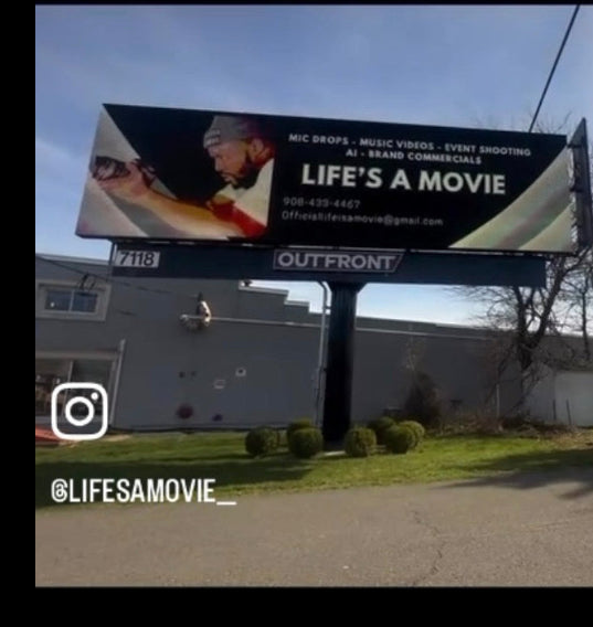 Billboard with 'Life's a Movie' advertisement on a clear day.